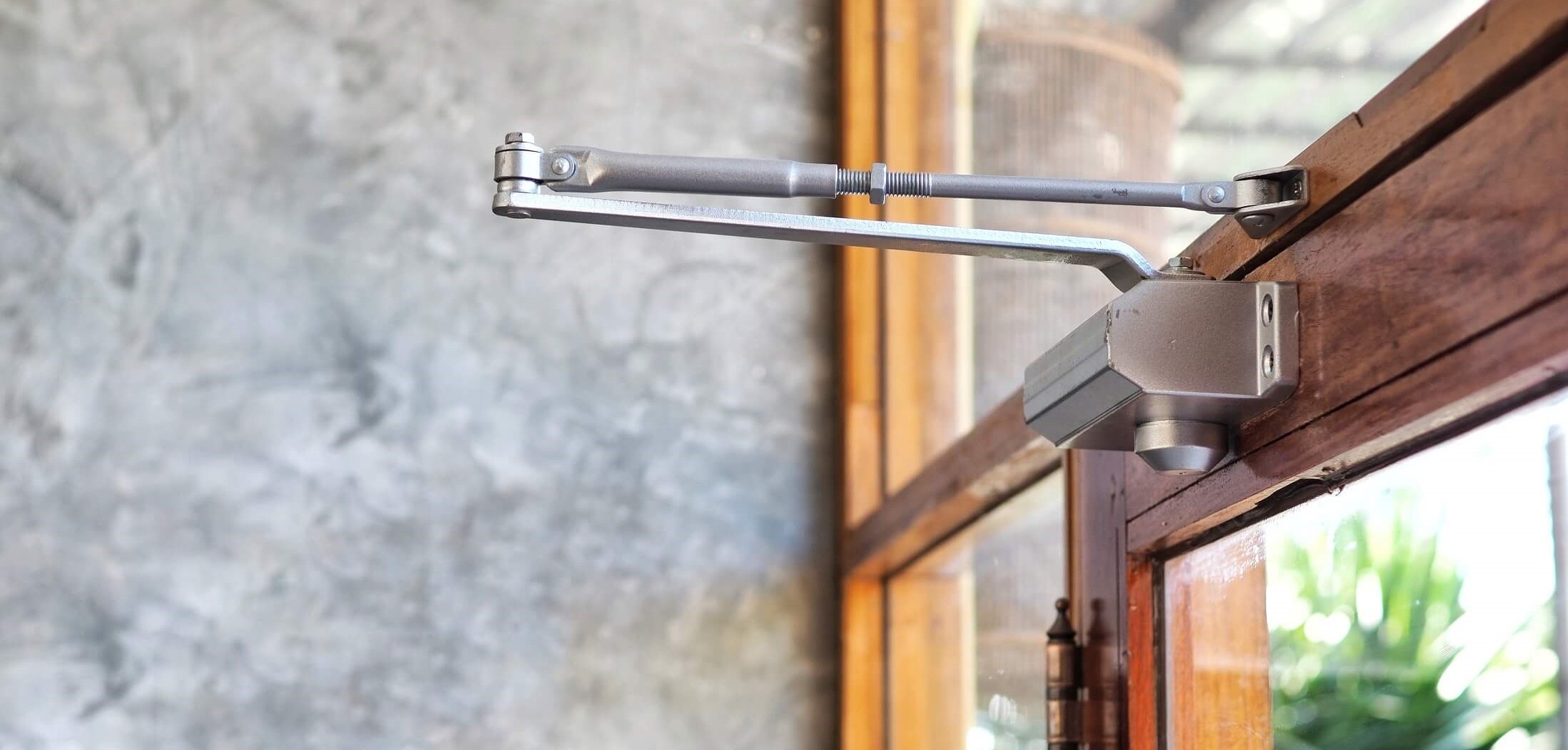 Surface Door Closer installed on wooden and glass door