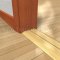Pemko 253x3FG Gold Anodized with Thermal Break on Wooden Floor