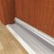 Pemko #405V Clear Anodized Automatic Door Bottom Applied onto Interior Wooden Door, Closed onto Doorway Threshold